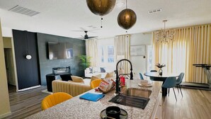 A modern kitchen with granite countertops, a built-in oven, and a dining area with a table and chairs. - Spacious 4 bedroom house with fitness room and WiFi in charming Glenn Heights. (Glenn Heights)