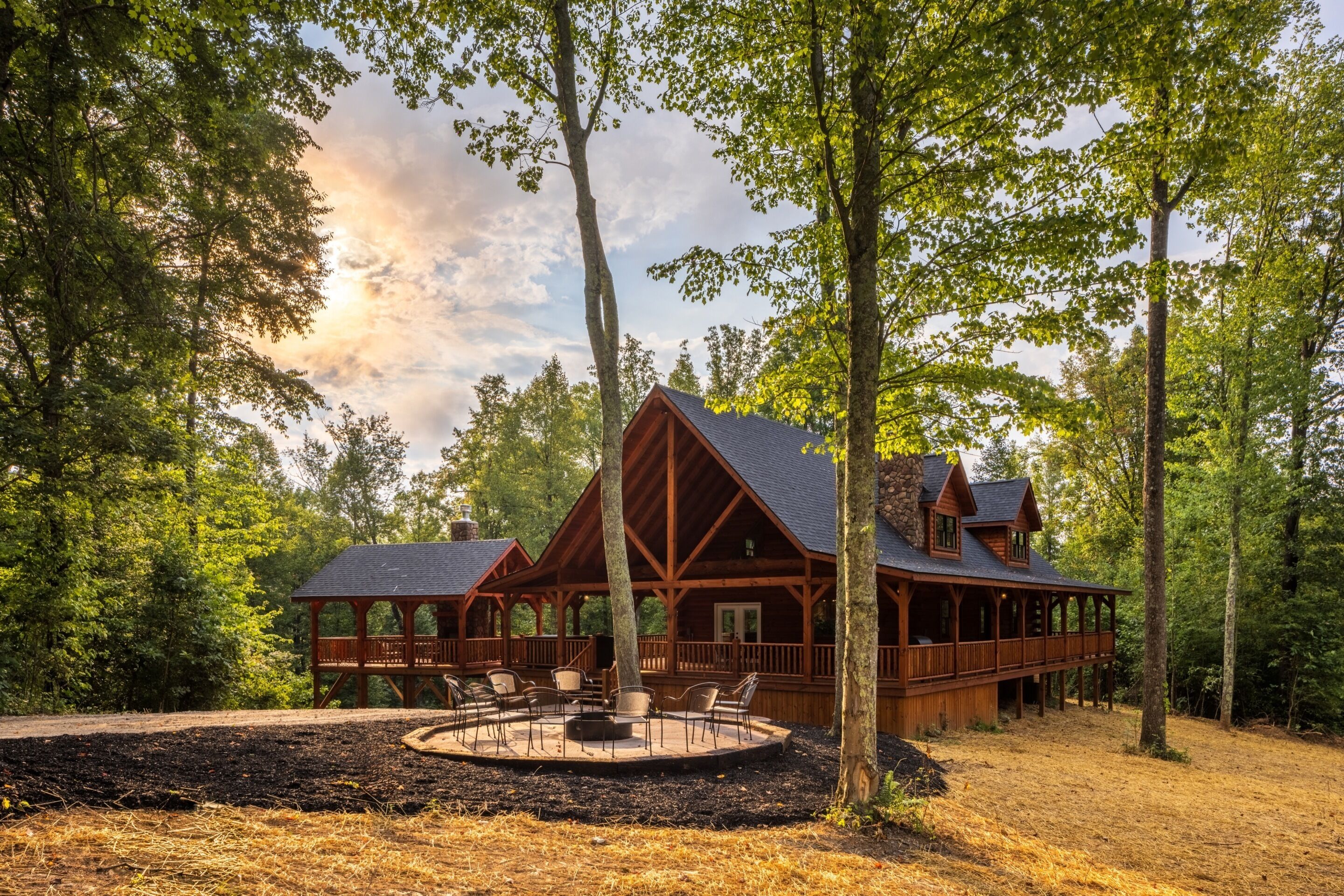 Eine Hütte mit überdachter Terrasse und Sitzgelegenheit im Freien.