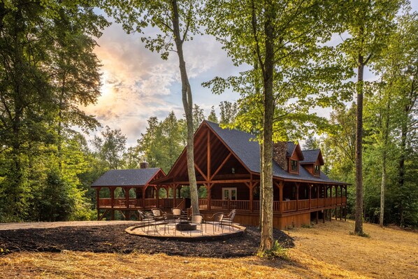 A cabin with a covered deck and outdoor seating area. - Moonlight Ridge Lodge - Hocking Hills (Logan)