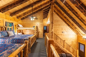 A log cabin room with a loft bed, a lower bunk bed, and a staircase. - Moonlight Ridge Lodge - Hocking Hills (Logan)