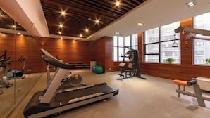 Une salle de sport équipée de tapis de course, de ballons d’exercice et d’appareils de musculation.