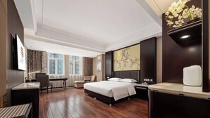 Une chambre d’hôtel avec un lit, un bureau, une chaise et une grande fenêtre.