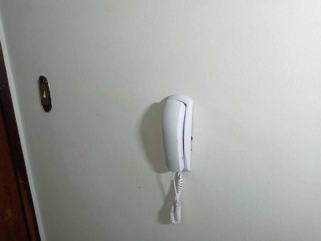 Un teléfono blanco sujeto a la pared.