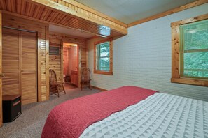 A cozy room with a bed, a wooden chair, and a small desk.
