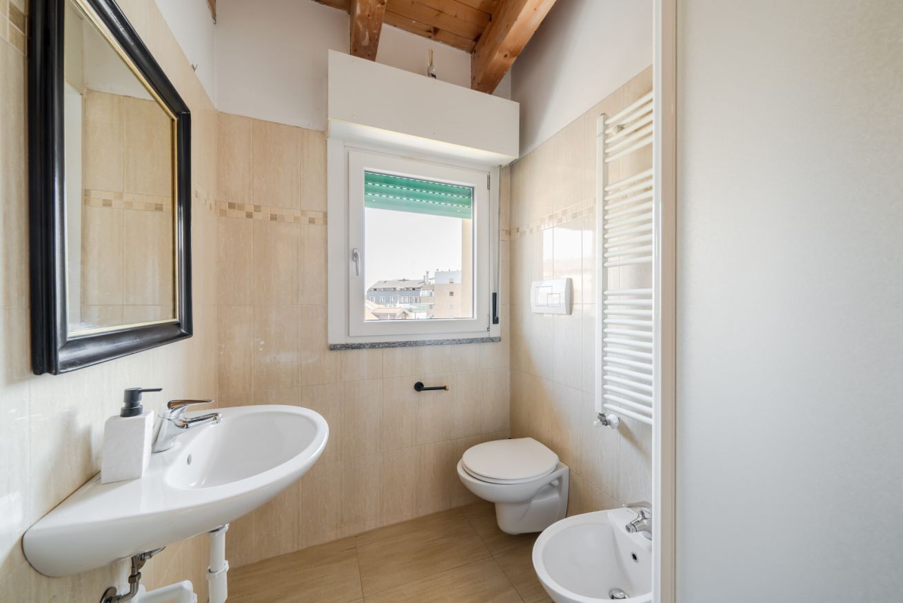 Un baño pequeño con lavabo, inodoro y ventana.