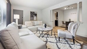 Una sala de estar moderna con un sofá modular, una mesa de centro redonda y un tapete mullido.
