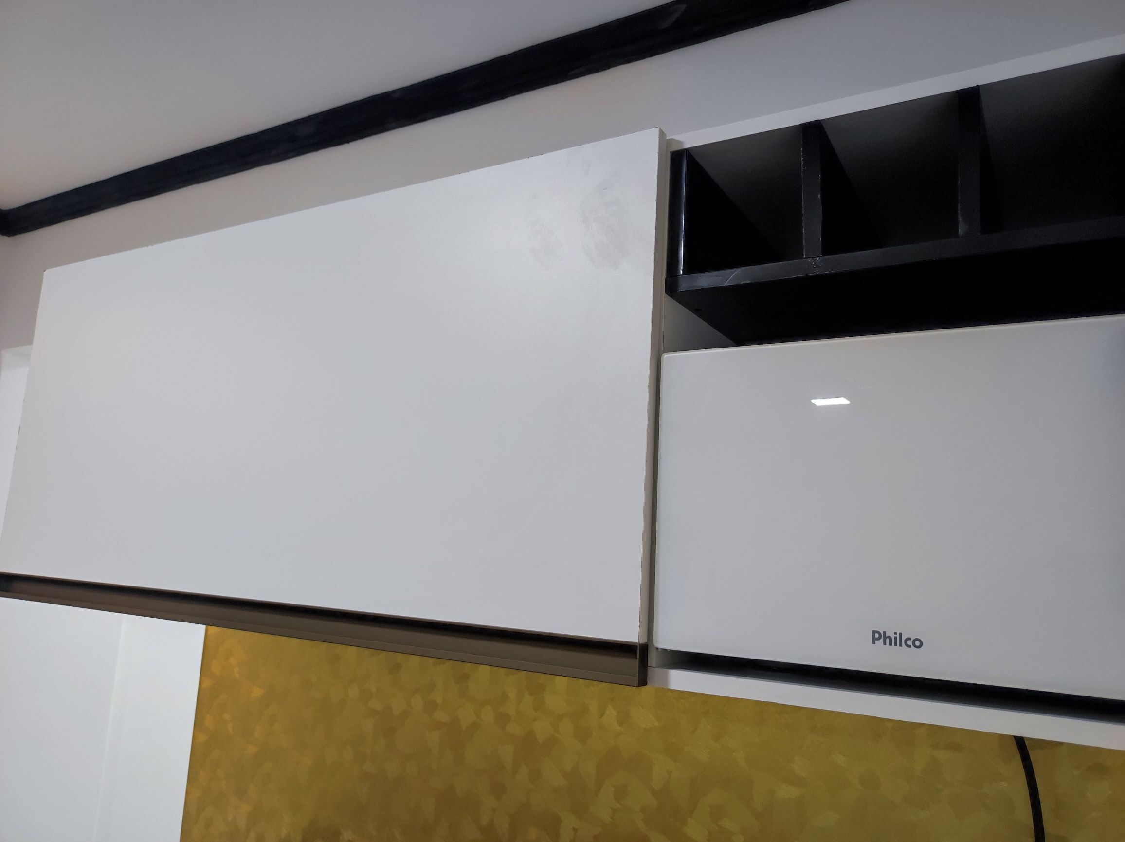 A white cabinet with a black handle and a white cabinet with the brand name 'Philco' on it.