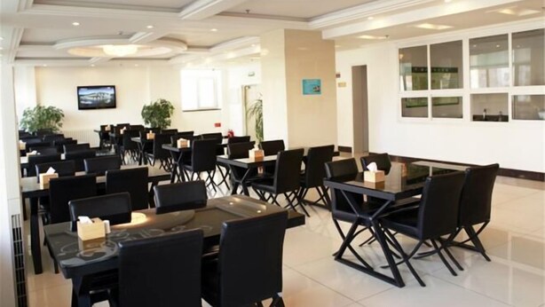 A hotel dining area with multiple tables and chairs, a chandelier, and a television on the wall. - Runyang Jiayue Hotel (Dalian Jinzhou Railway Station) (Dalian)