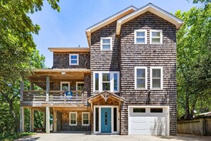 A two-story house with a covered porch, a garage, and a front door. - Big Guppy: Pool, Elevator, Hot Tub, Dog-Friendly (Duck)