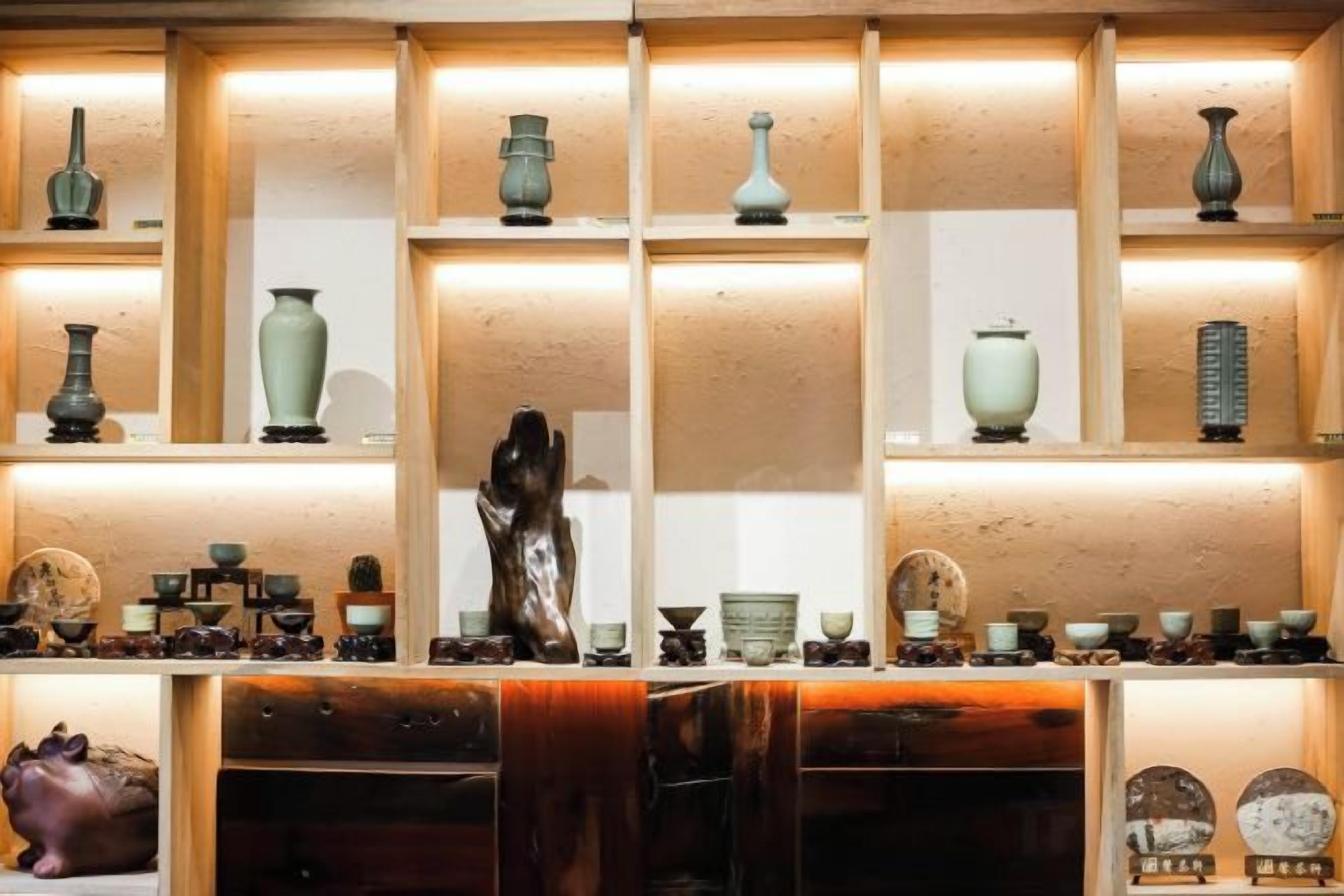 Une exposition de divers vases et sculptures en céramique, présentés sur des étagères.