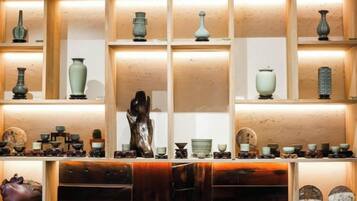 Une exposition de divers vases et sculptures en céramique, présentés sur des étagères.