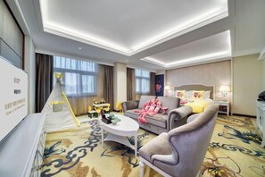 A hotel room with a sofa, a small table, a tent-like structure, and a bed with a headboard. - Zhongwei Sunny Hotel (Jinyun)