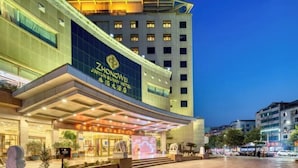 A hotel with a modern facade, a prominent entrance, and a spacious outdoor area. - Zhongwei Sunny Hotel (Jinyun)