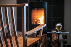 A wooden chair and a glass of beer in front of a fireplace. - Bettei Fujiya (Hatsukaichi)