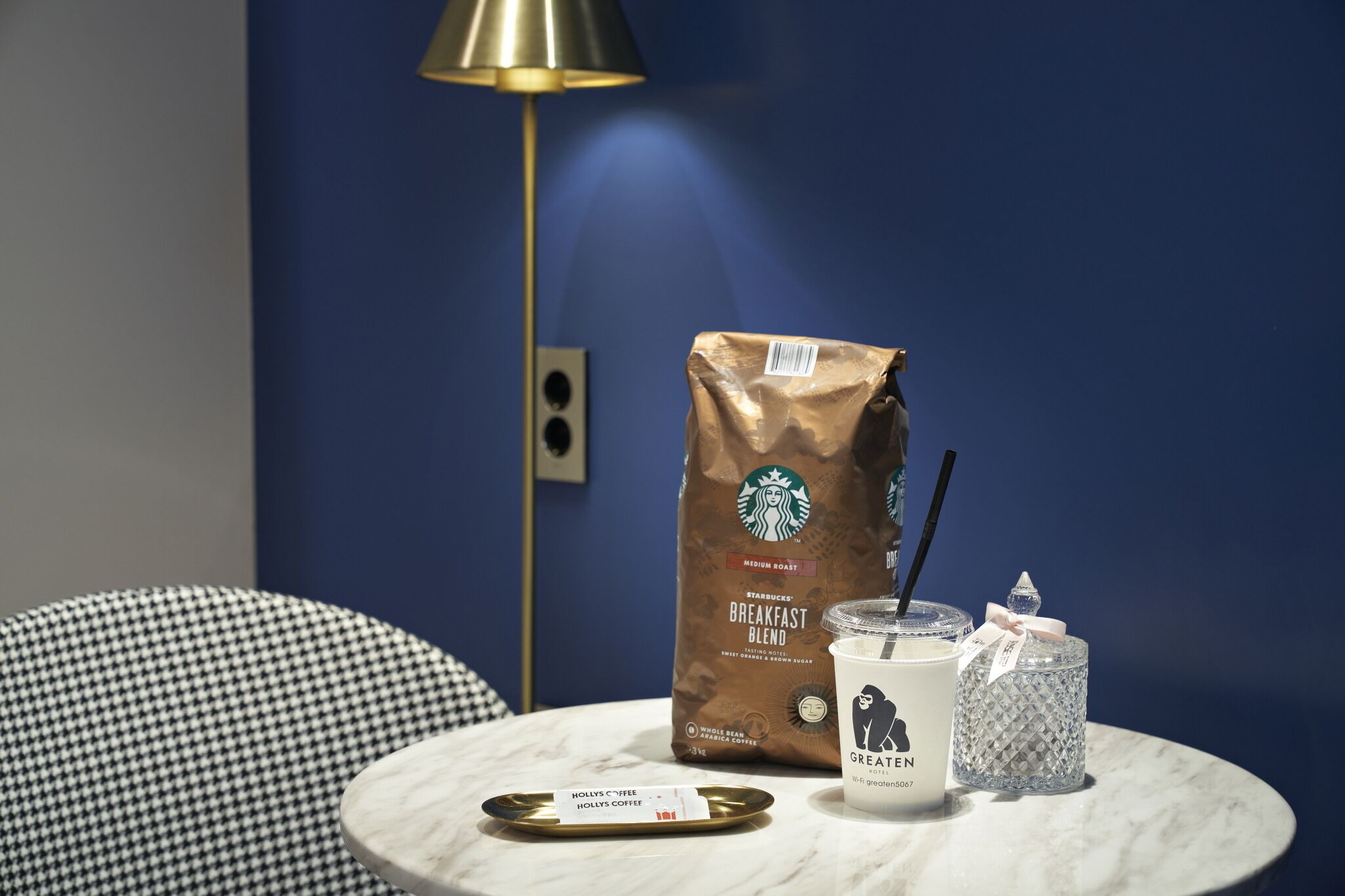 A table with a Starbucks bag, a coffee cup, and a glass jar.