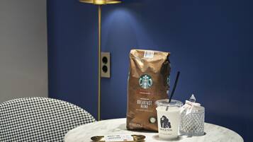 Uma mesa com um saco da Starbucks, uma xícara de café e um pote de vidro.