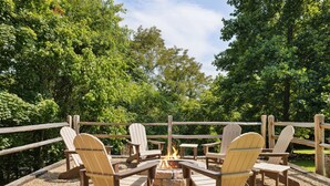 An outdoor seating area with Adirondack chairs and a fire pit. - Little Mountain Cabin - 3-Bedroom Retreat with Hot Tub, Fire Pit, Games, and Serene Nature Views (Sevierville)