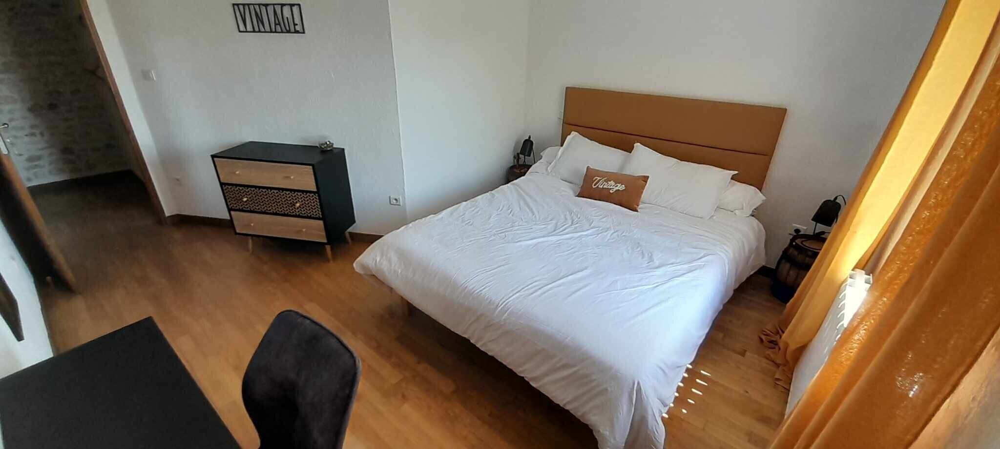 A bedroom with a bed, a nightstand, a dresser, and a chair.