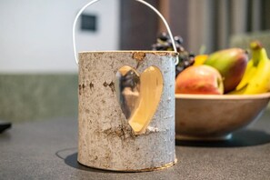 Eine rustikale Tasse mit Herzförmigem Ausschnitt, eine Obstschale und ein unscharfer Hintergrund.