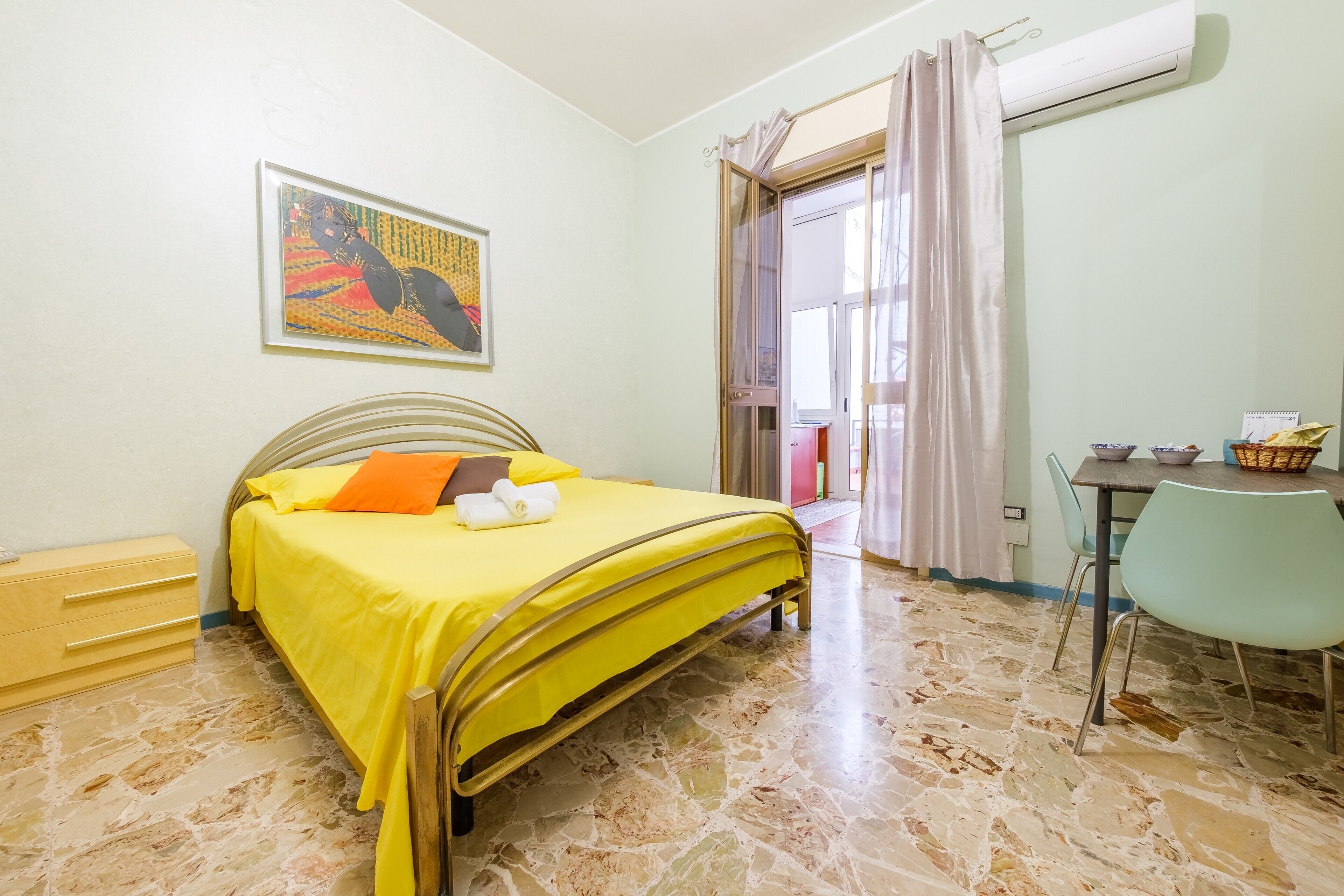 Una stanza con un letto, un tavolo e una sedia.