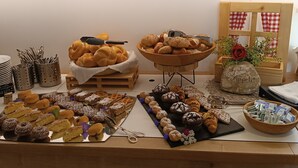 Una mesa de buffet con una variedad de productos horneados y pastelería.