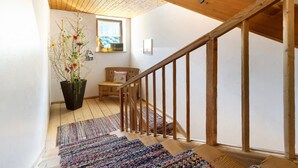 A wooden staircase with a handrail, a potted plant, a bench, and a window with a view. - Room 'Ederhof 7' with Mountain View, Shared Terrace, Wi-Fi, and Breakfast Included (Ahrntal - St.Peter)