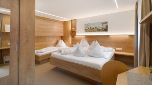 A modern hotel room with a wooden bed, bedside tables, a desk, and a wall-mounted artwork. - Room 'Ederhof 4' with Mountain View, Shared Terrace, Wi-Fi, Breakfast Included (Ahrntal - St.Peter)