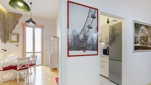 Eine moderne Küche mit Kühlschrank, einem Essbereich mit Tisch und Stühlen sowie einem gerahmten Bild an der Wand.