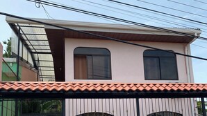 A two-story building with a tiled roof, a gated entrance, and a sign indicating a private property.