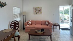 Una sala de estar con sofá, mesa de centro y ventilador de techo.