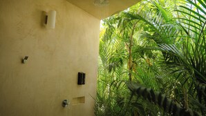A shower area with a ceiling showerhead, a wall-mounted soap dispenser, and a small shelf. - Villa Yahualli Punta Pérula, Jalisco (Pérula)