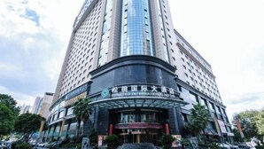 Un grand immeuble d’hôtel, doté d’une entrée incurvée et d’une enseigne indiquant « Songtao International Hotel ».
