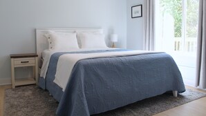 Ein Schlafzimmer mit Bett, Nachttisch und Fenster.