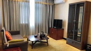 A living room with a sofa, coffee table, and a cabinet. - Jinyuan Hotel (Nang County)