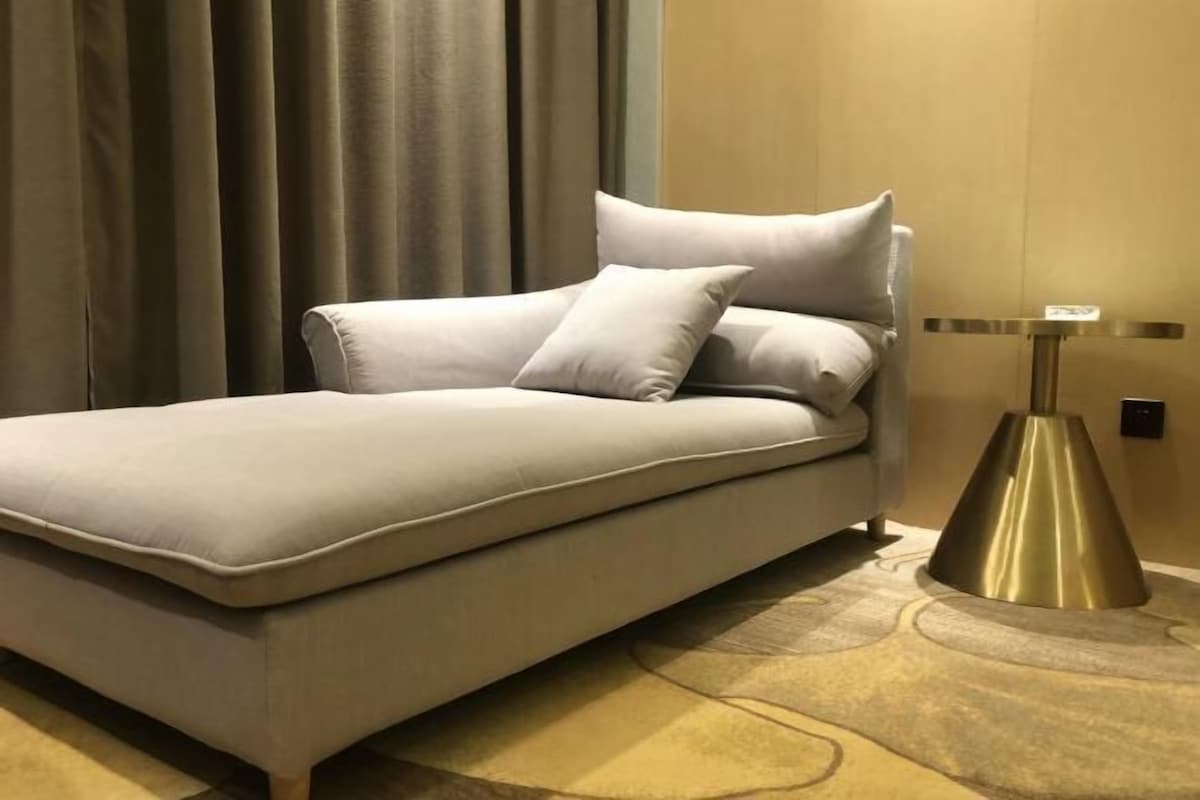 Una cama con almohadas, una mesita de noche y una lámpara.