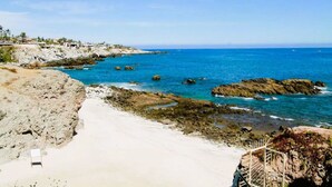 A coastal beach scene with rocky terrain and a clear blue sea. - Spectacular Ocean-View  Pet friendly Condo. Walk to Beach, Bars & Dining (Cabo Bello)