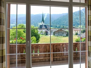 Enjoy a panoramic view of the rolling hills and a nearby church from the comfort of this room.