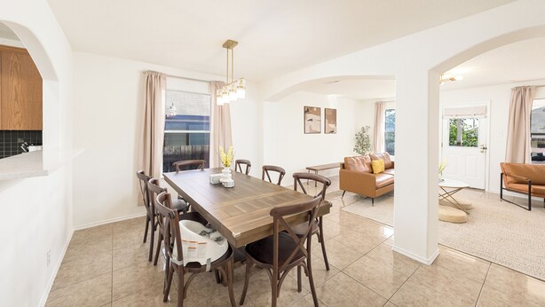 A spacious dining area with a long wooden table and multiple chairs, a kitchen area with wooden cabinets, and a living room with a sofa and a coffee table. - Spacious 4BR w Game Room - 15 min to Seaworld (San Antonio)