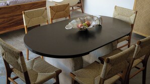 A round table with a dark surface and a woven chair with a cushion. - Villa Quetzalpapalotl (Pérula)