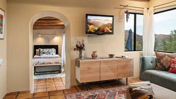 Une chambre à coucher avec un lit, une télévision, une commode et une vue sur l’extérieur.
