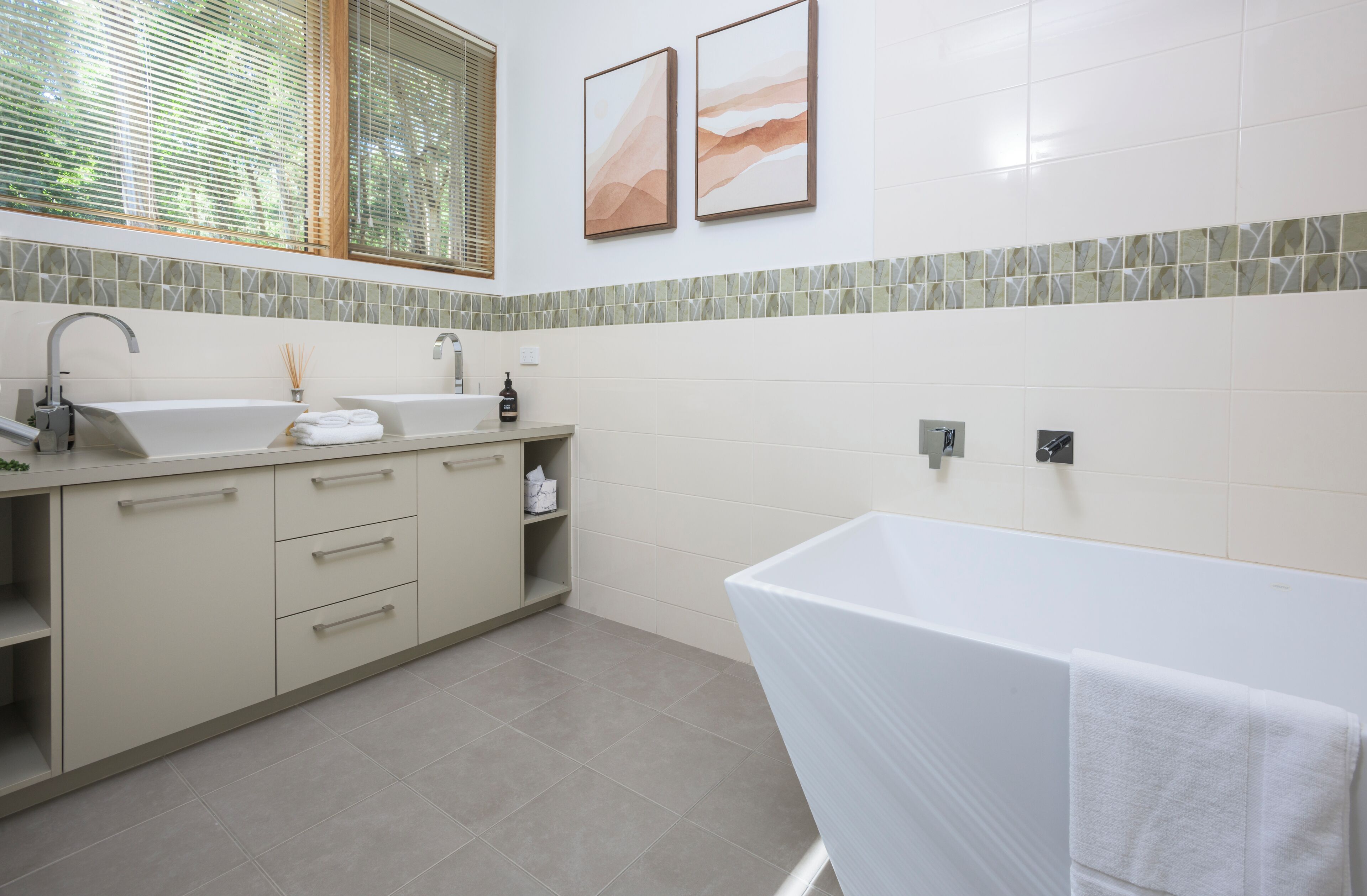 Een moderne badkamer met een bad, een wastafel en een badkamermeubel.