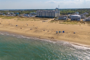 An aerial view of a beach with a hotel complex in the background.