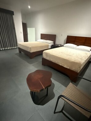 Ein Hotelzimmer mit zwei Betten, einem kleinen Tisch und einem Stuhl.
