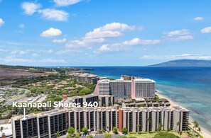 A high-rise hotel with multiple balconies overlooking a beach and ocean.