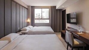 A hotel room with two beds, a desk, a chair, a TV, and a window with a city view. - River inn ZihLi (Kaohsiung)
