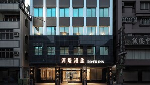 A modern hotel building with a prominent 'River Inn' sign at the entrance. - River inn ZihLi (Kaohsiung)