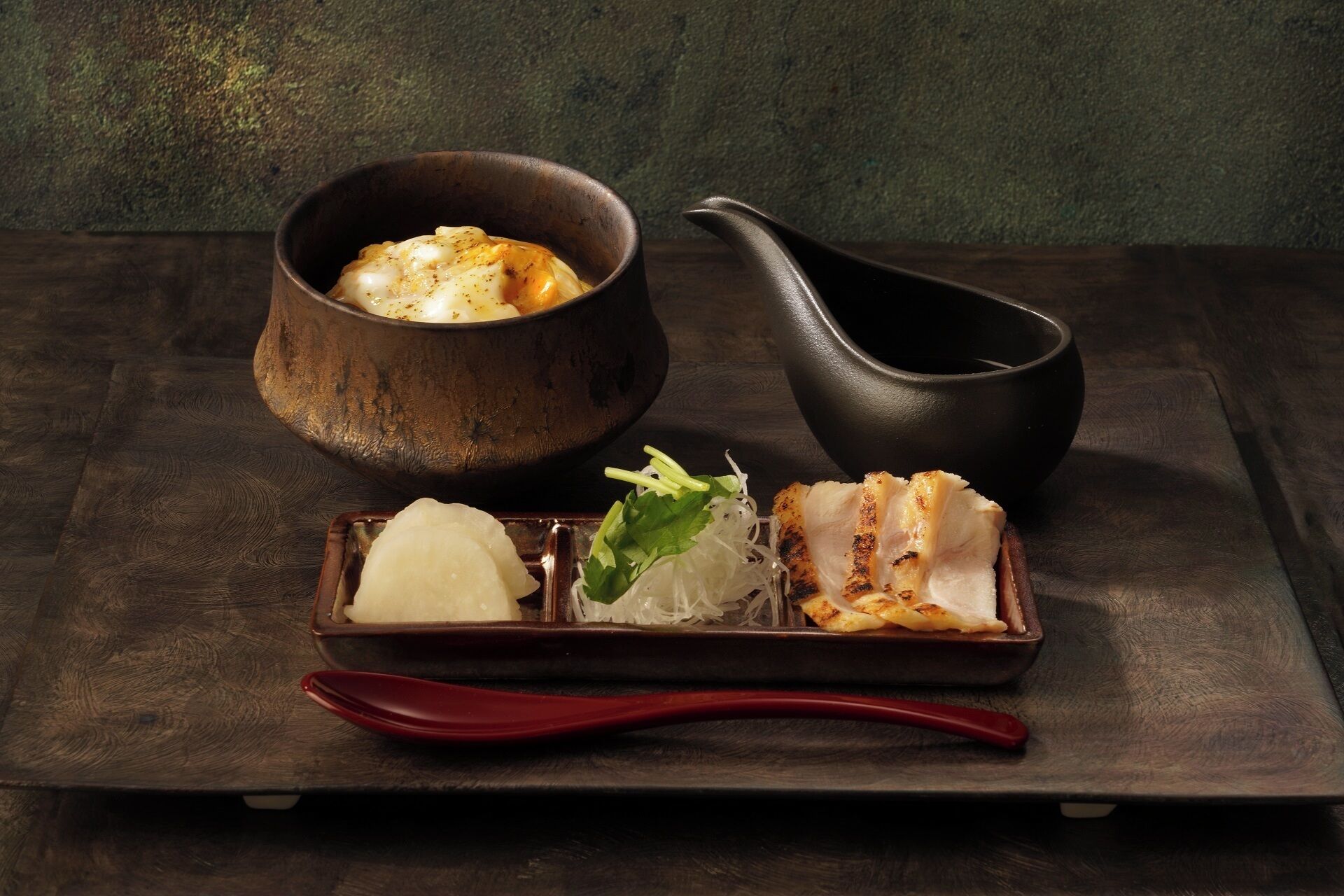 Una comida tradicional japonesa con un tazón de sopa, un plato pequeño de arroz y un trozo de pescado a la parrilla sobre una bandeja de madera.