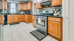A kitchen with wooden cabinets, a stainless steel stove, and a tiled backsplash.
