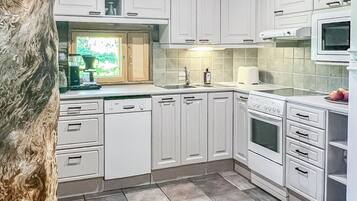 Een koelkast, een magnetron, een vaatwasser, kookgerei, borden en bestek