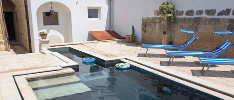 Alberca al aire libre y camastros